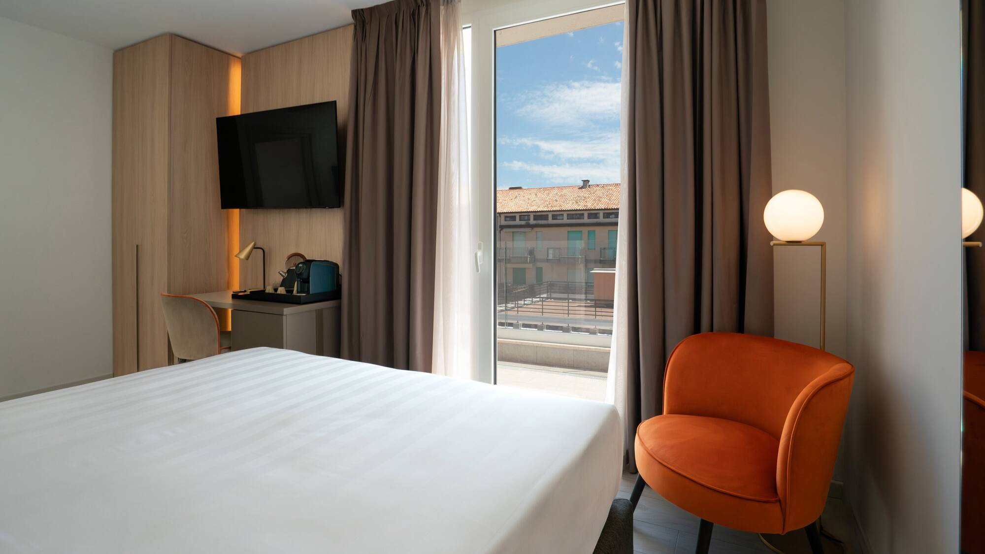 a room with a bed and a chair and a television