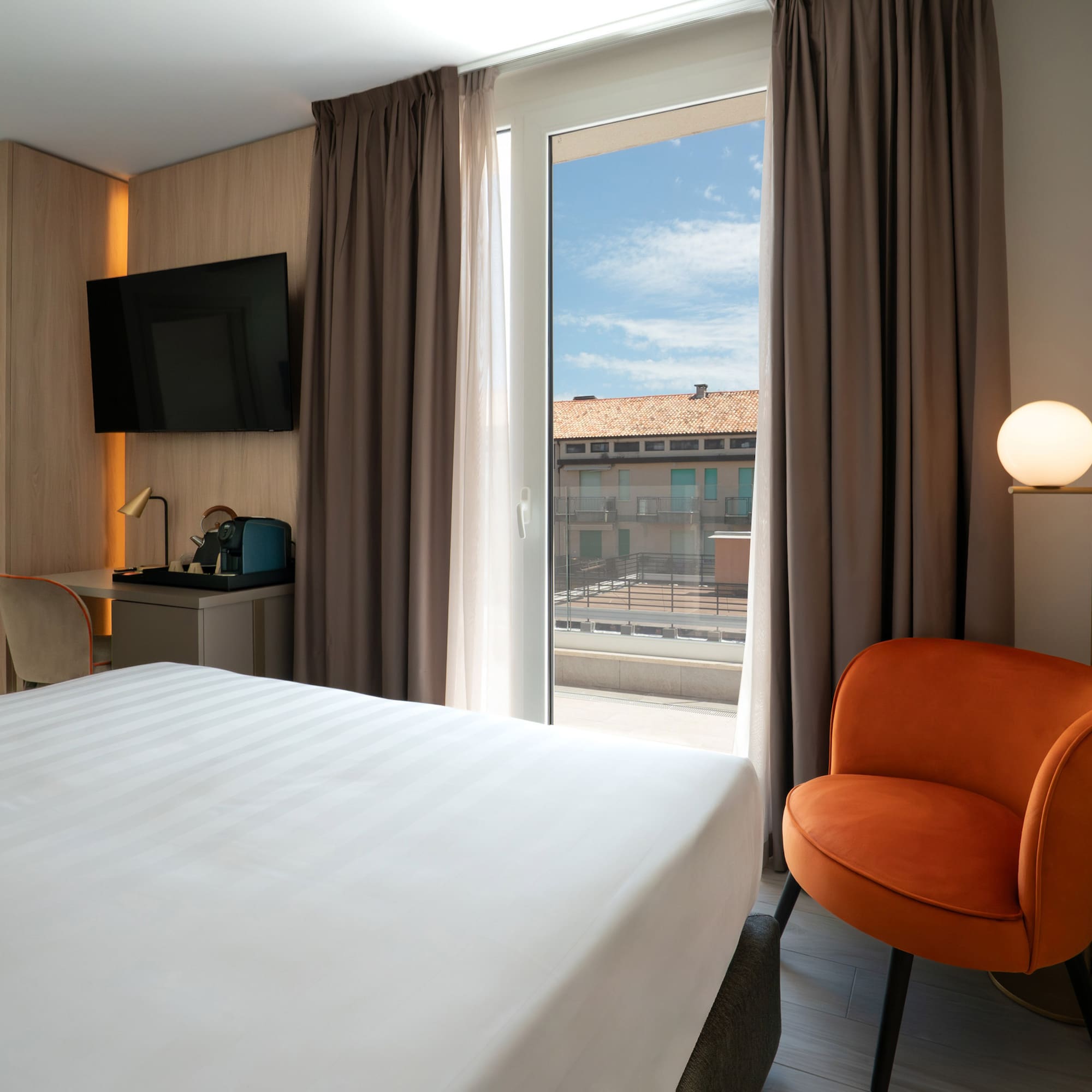 a room with a bed and a chair and a television