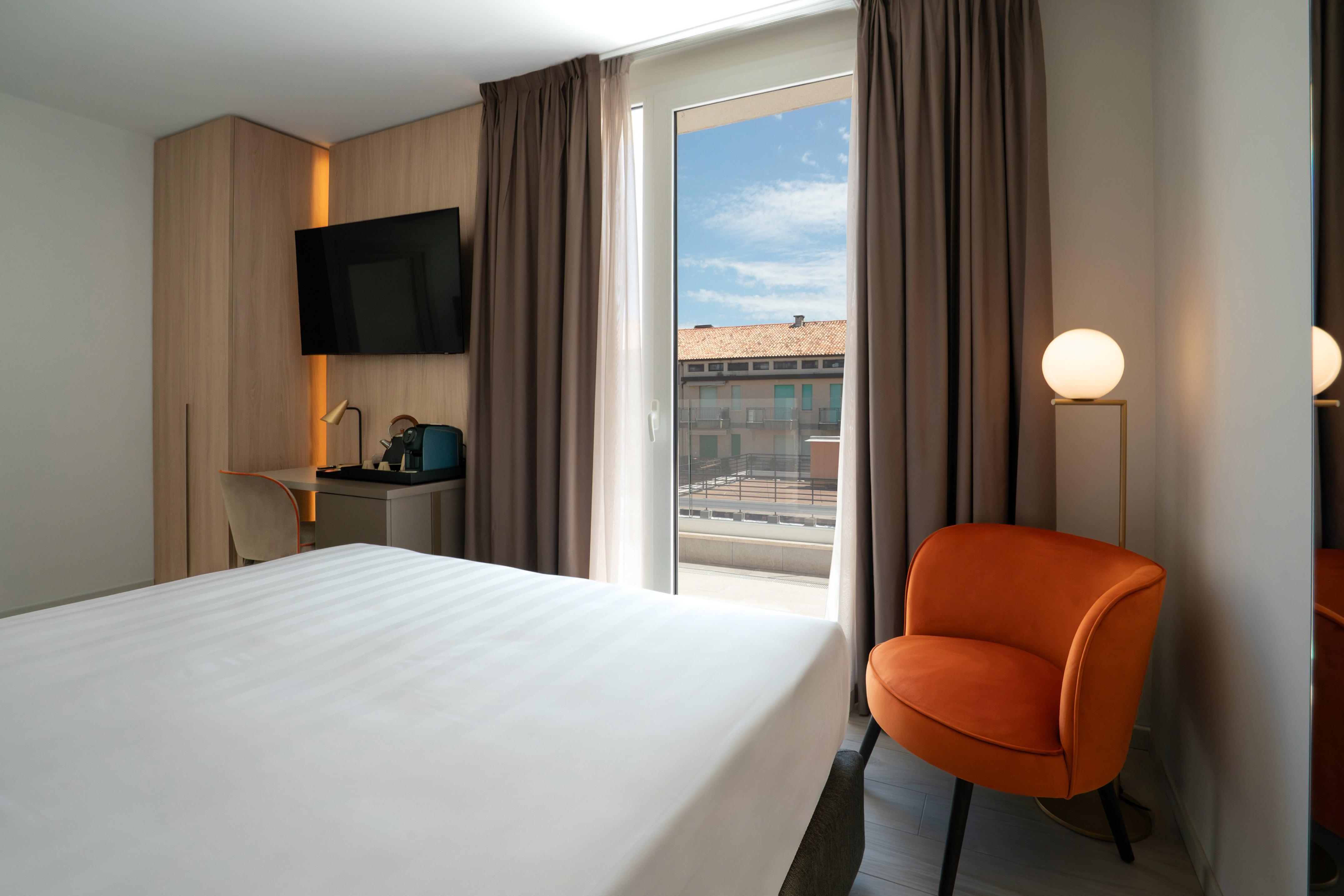 a room with a bed and a chair and a television