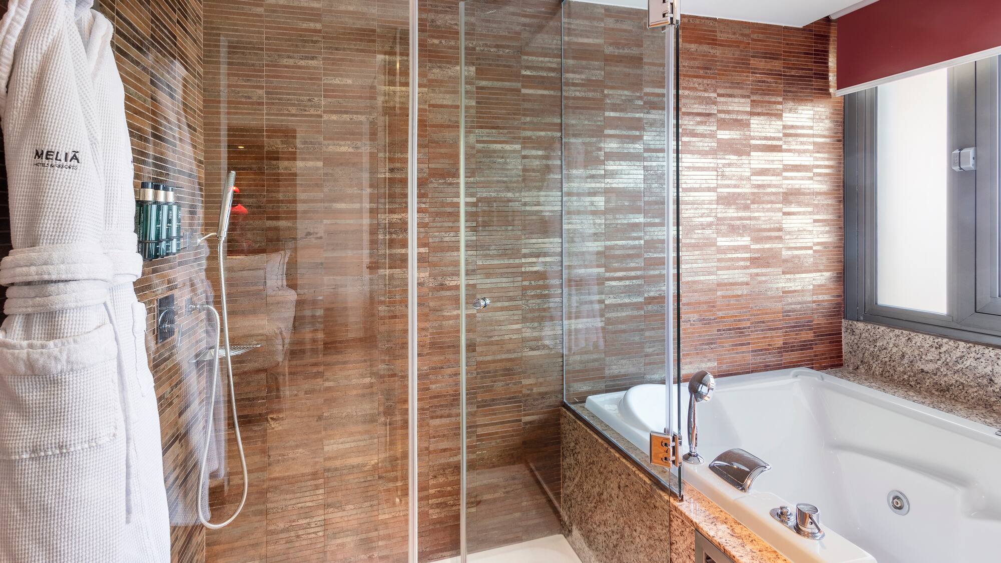 a bathroom with a glass shower and tub