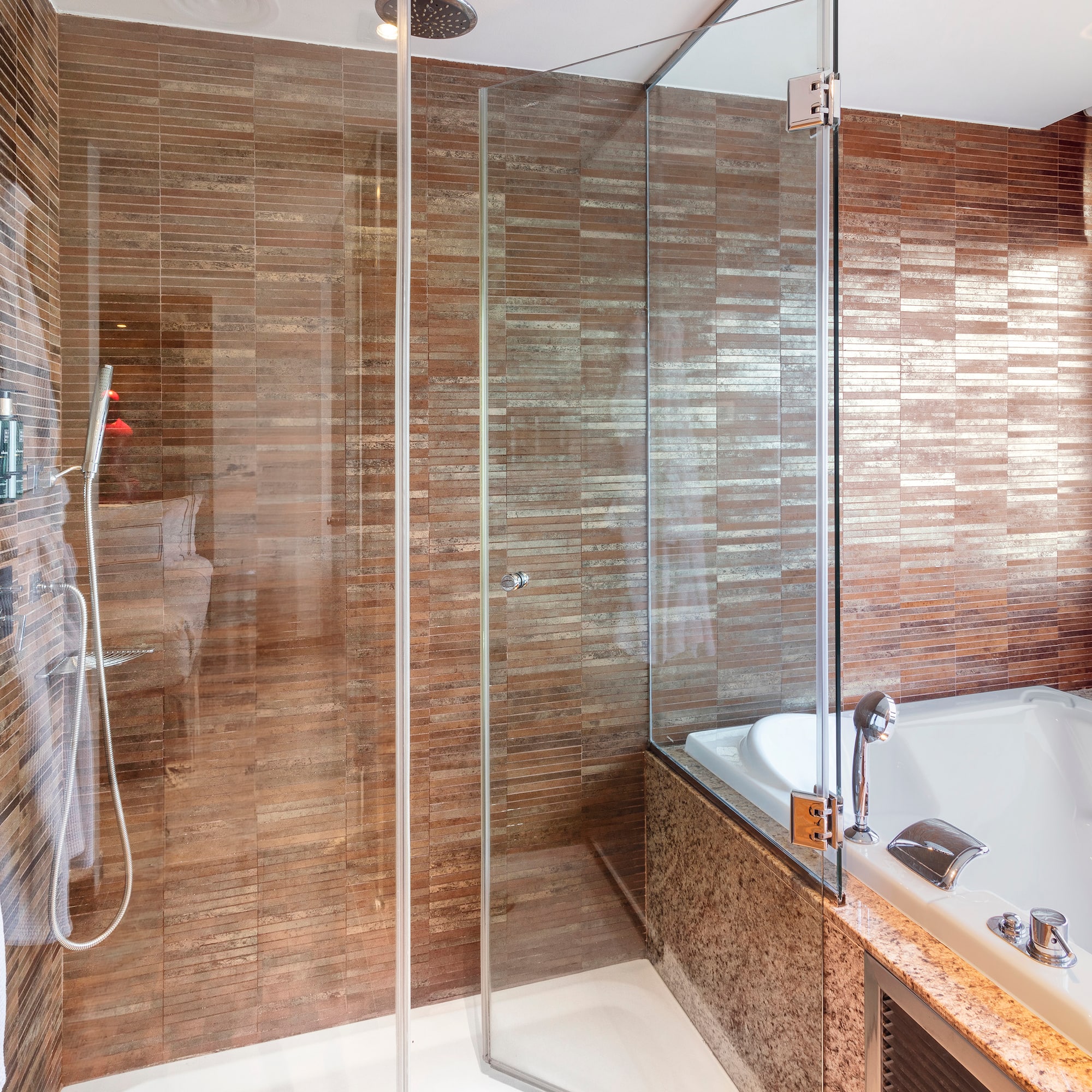 a bathroom with a glass shower and tub