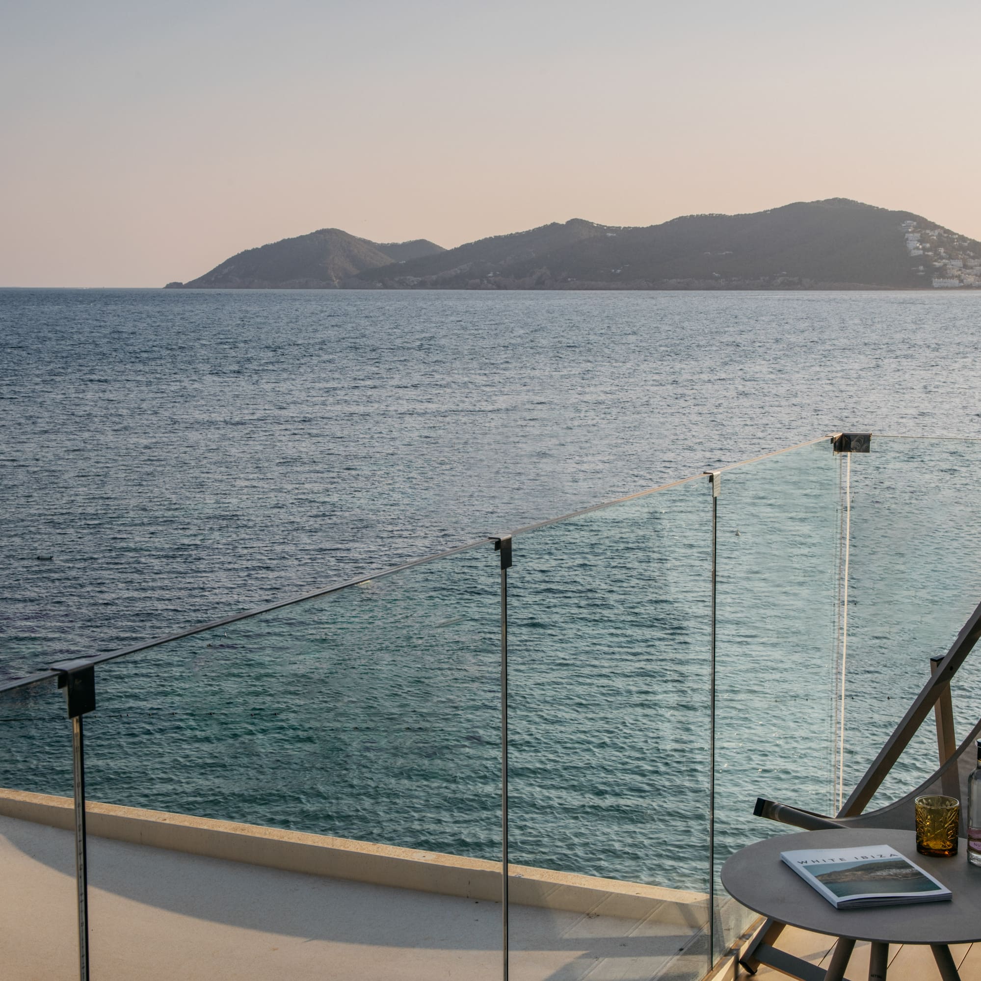 a table and chairs on a deck overlooking a body of water