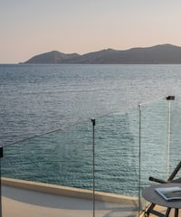 a table and chairs on a deck overlooking a body of water