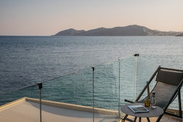 a table and chairs on a deck overlooking a body of water
