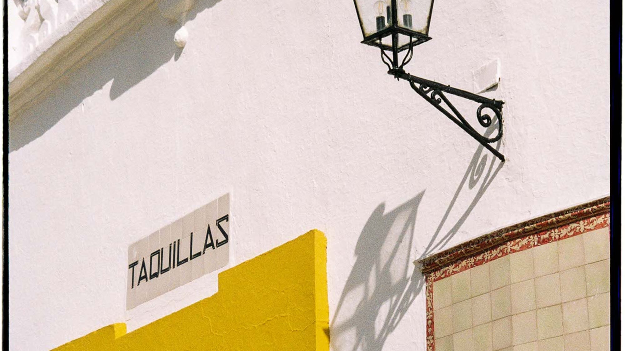 a white building with a lamp on the side