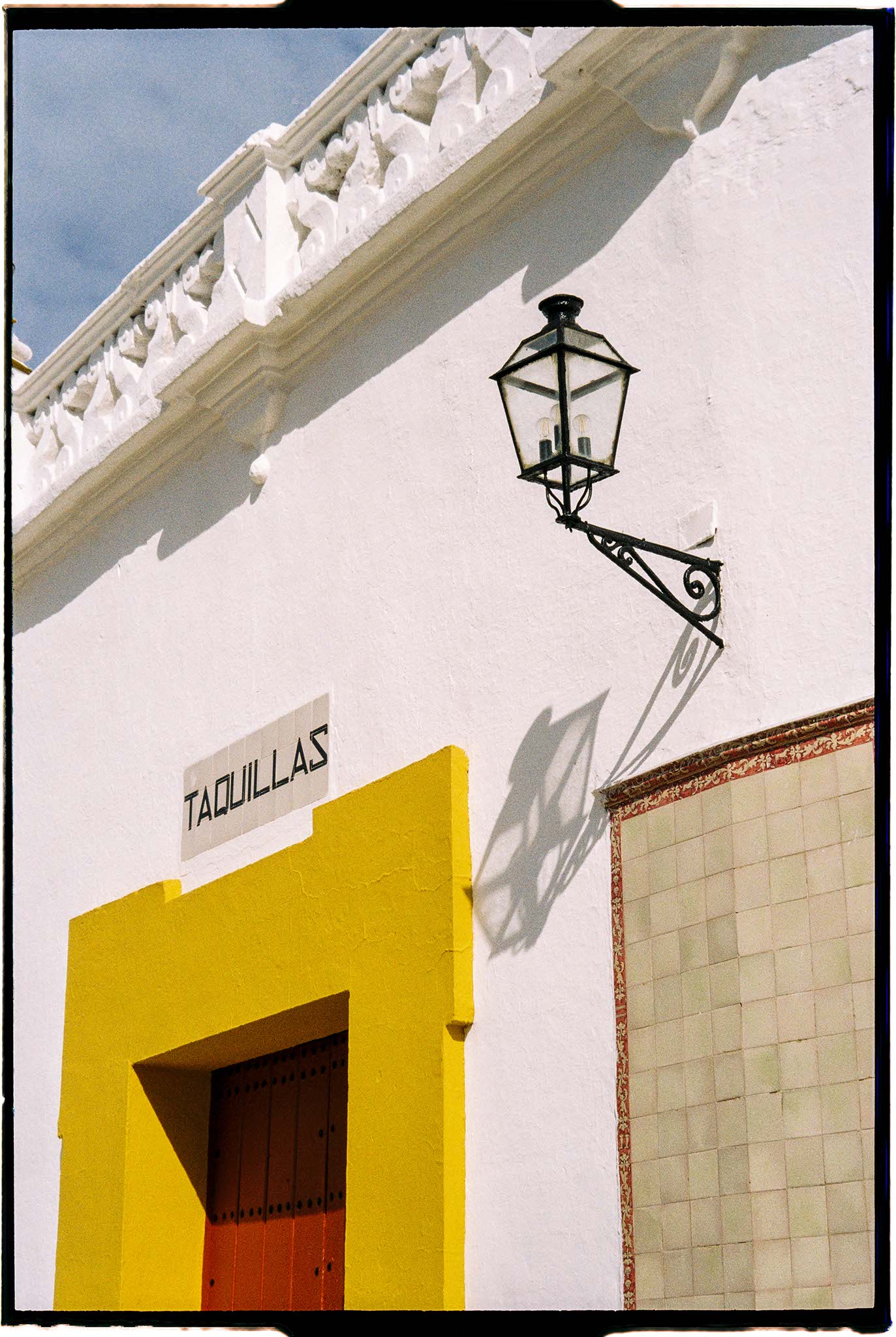 a white building with a lamp on the side