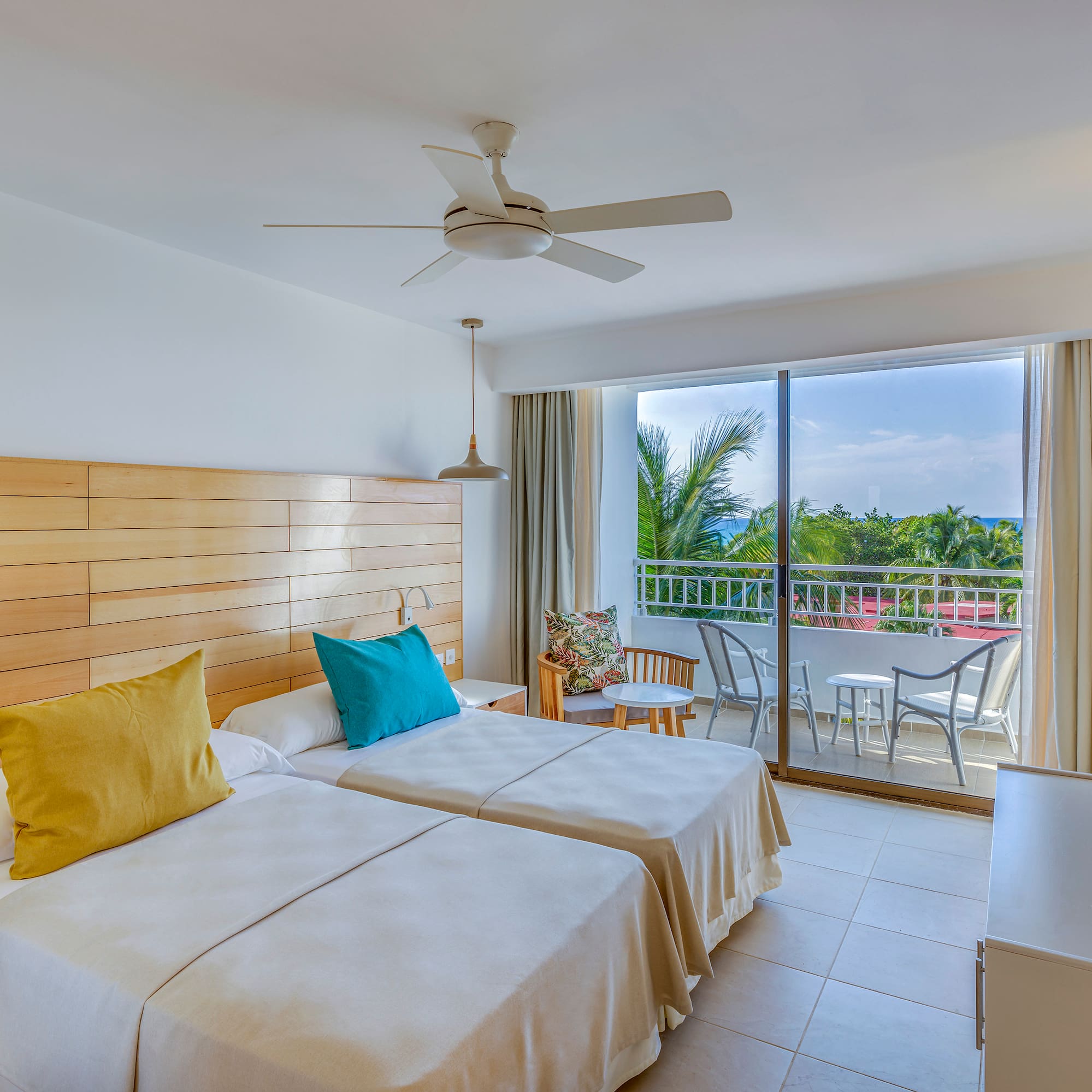 a room with two beds and a ceiling fan
