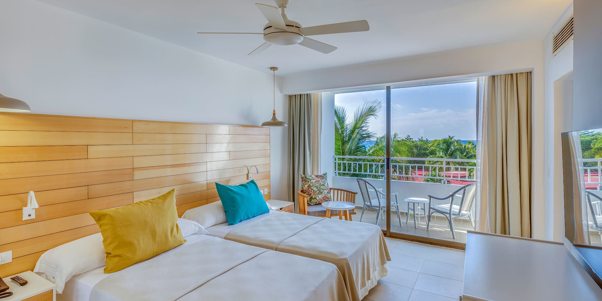 a room with two beds and a ceiling fan