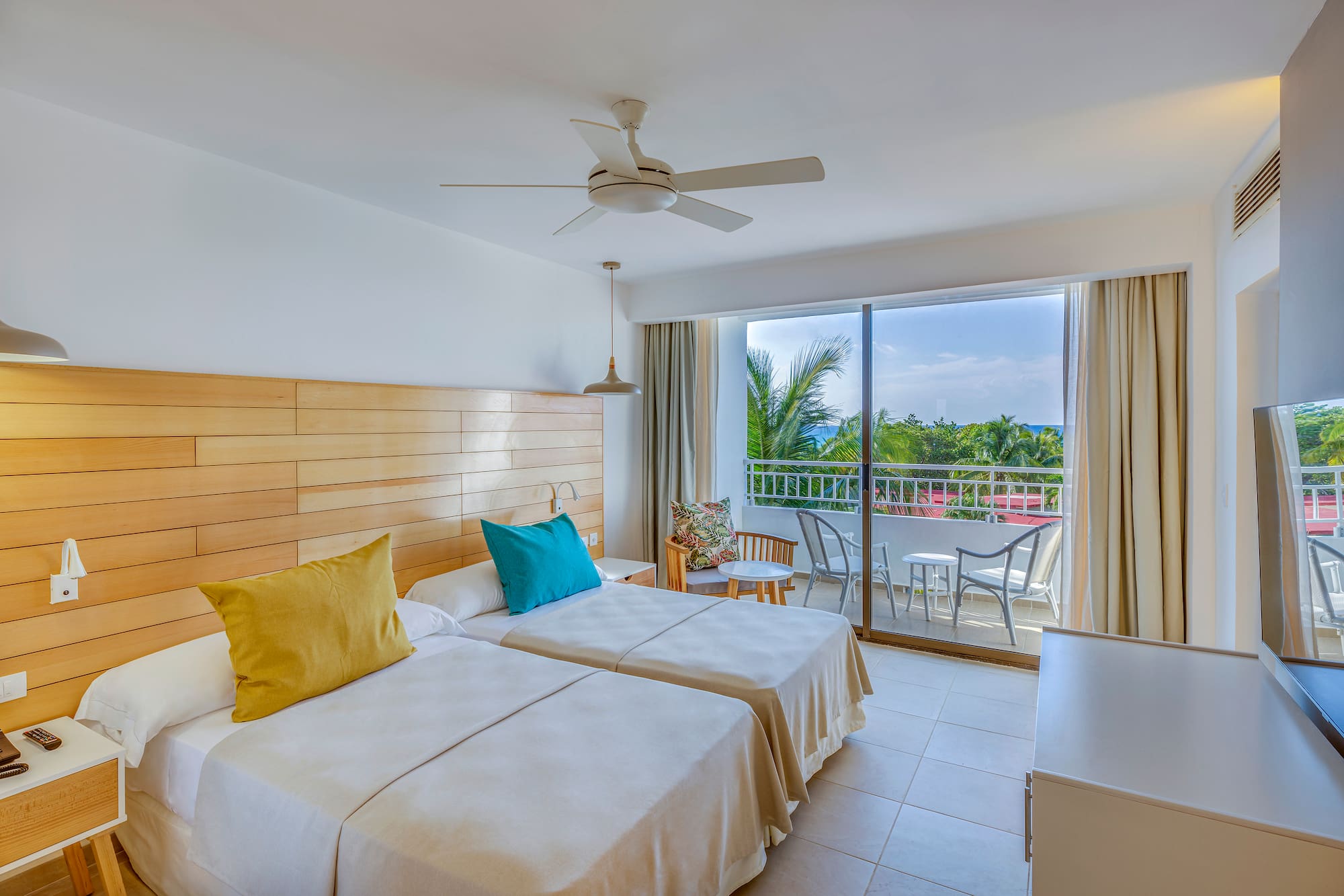 a room with two beds and a ceiling fan