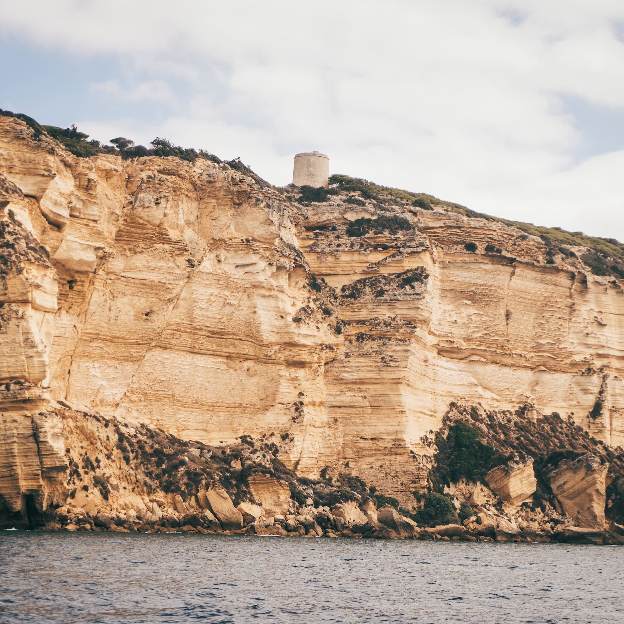a large cliff with a tower on top of it