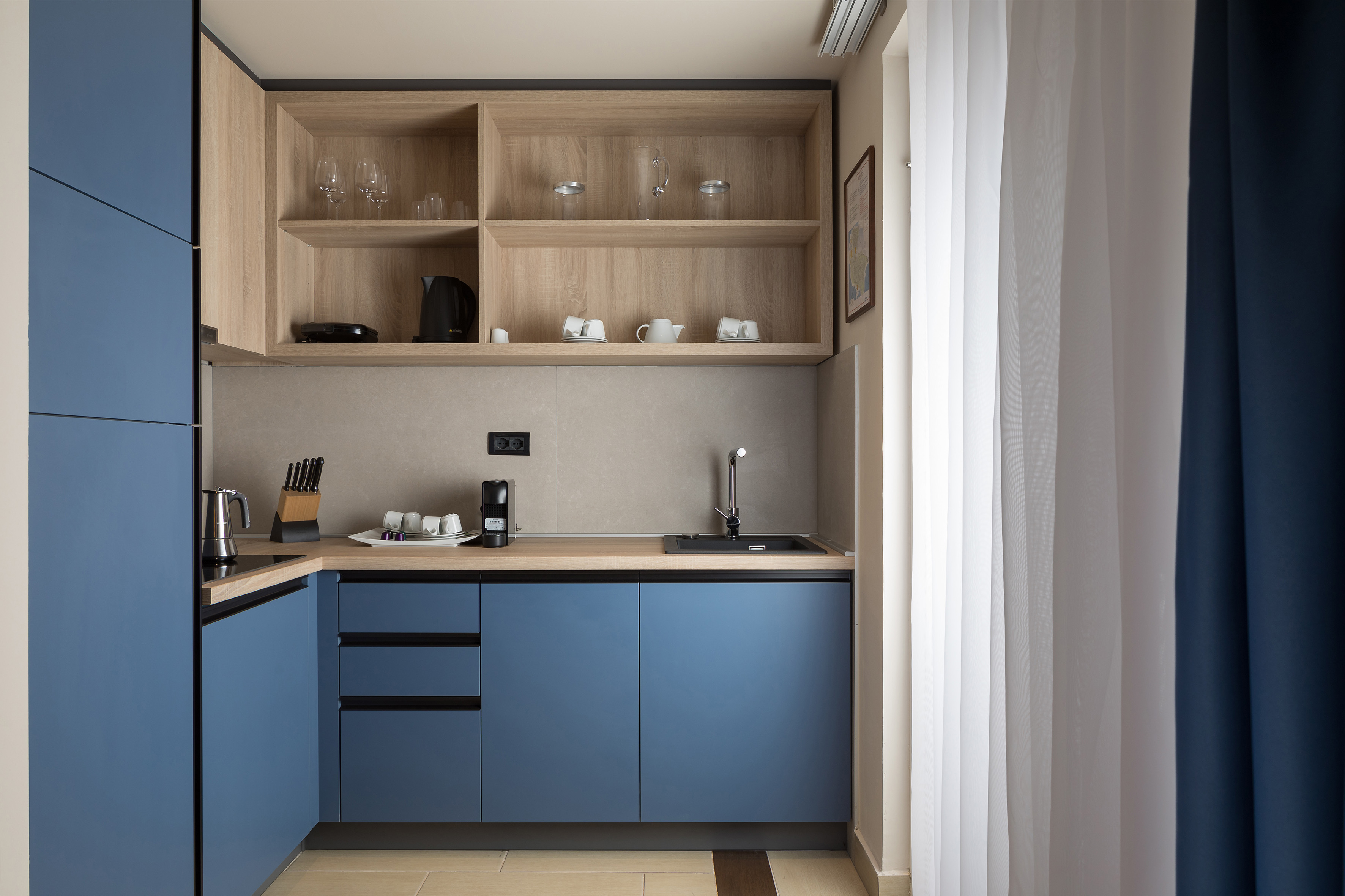 a kitchen with blue cabinets and shelves