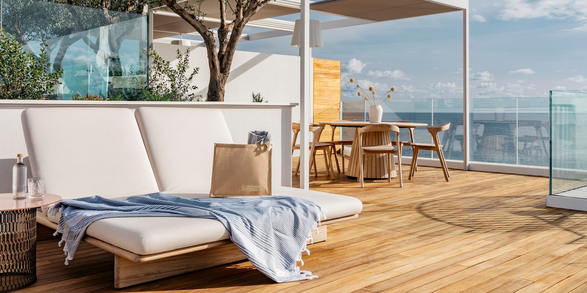 a deck with a chair and table and chairs and a tree