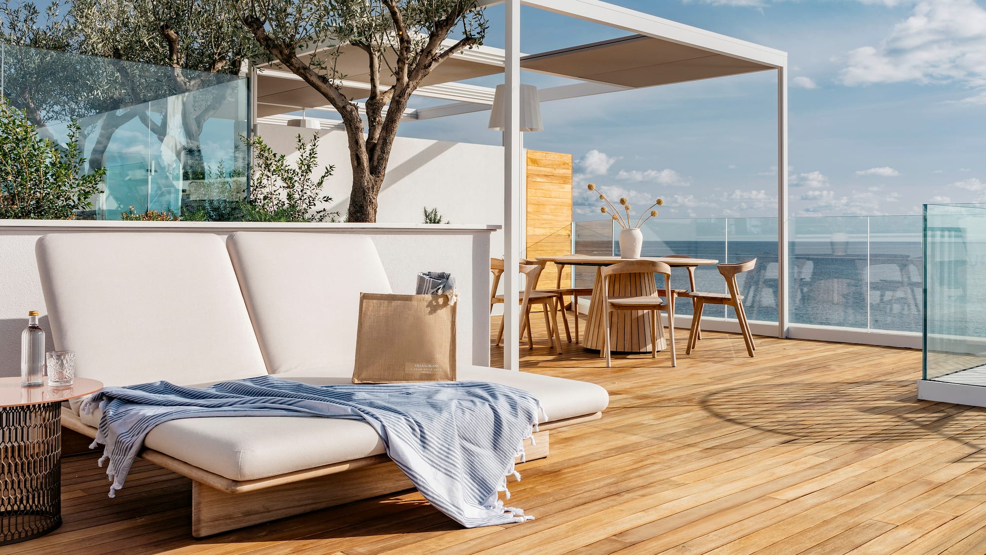 a deck with a chair and table and chairs and a tree