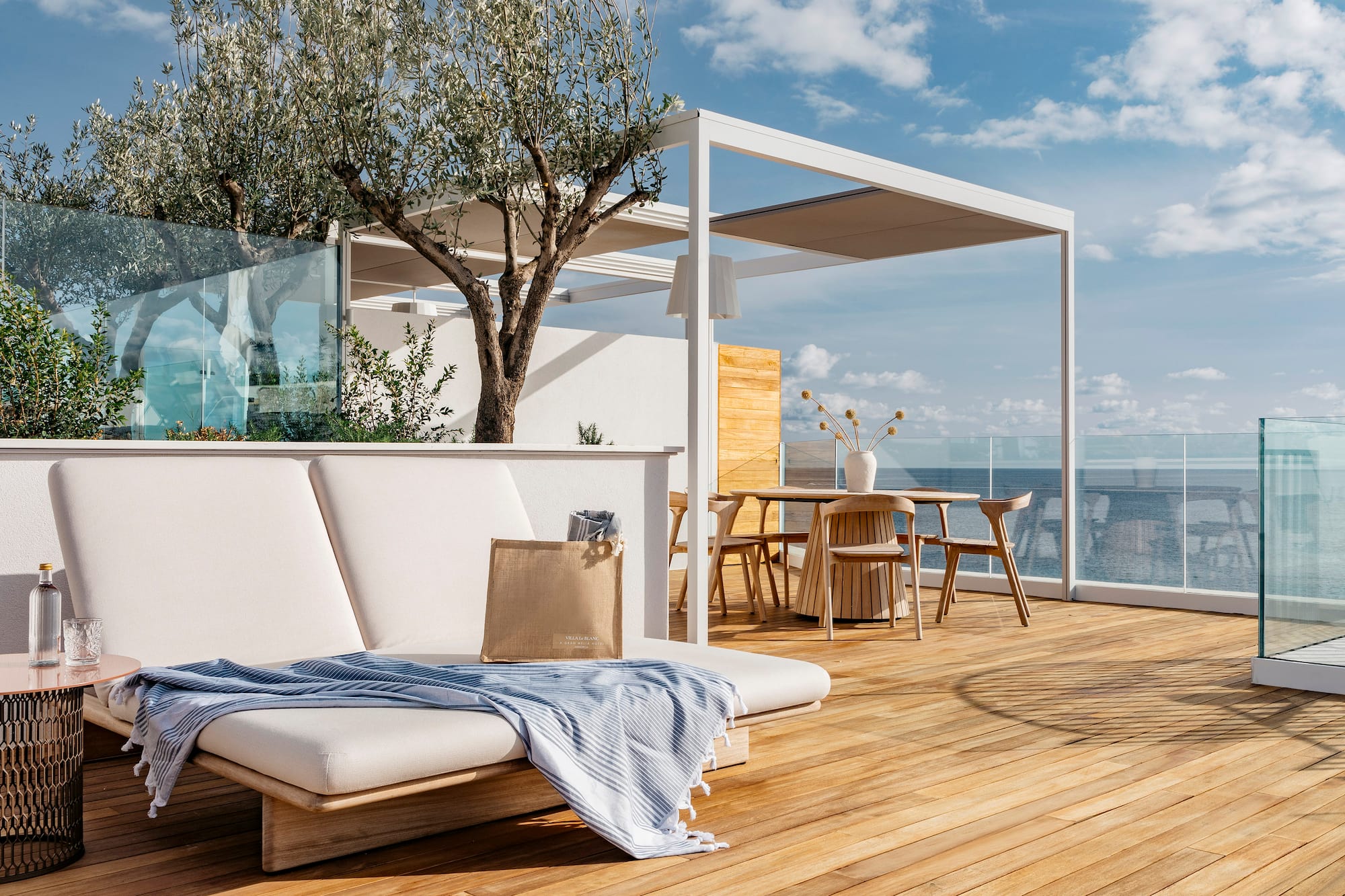 a deck with a chair and table and chairs and a tree