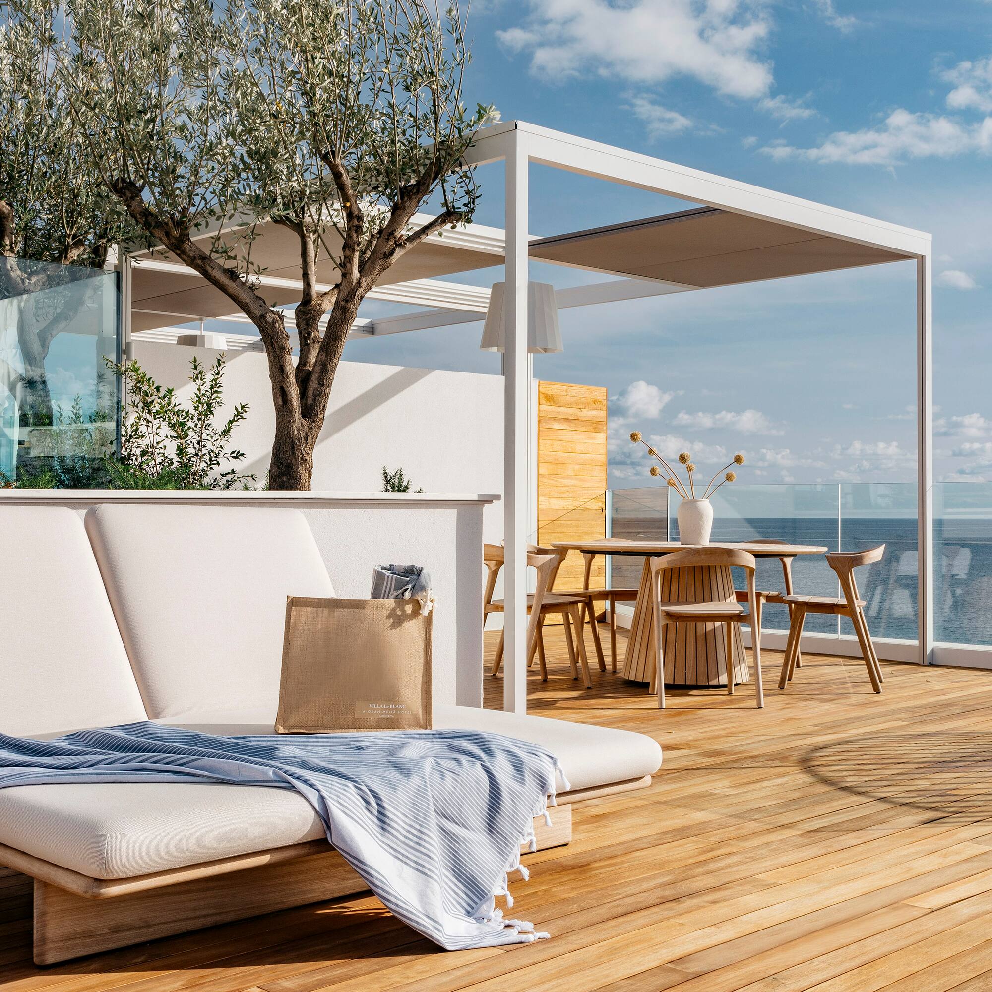 a deck with a chair and table and chairs and a tree