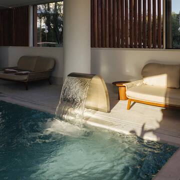 a pool with a waterfall and couches