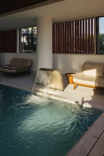 a pool with a waterfall and couches