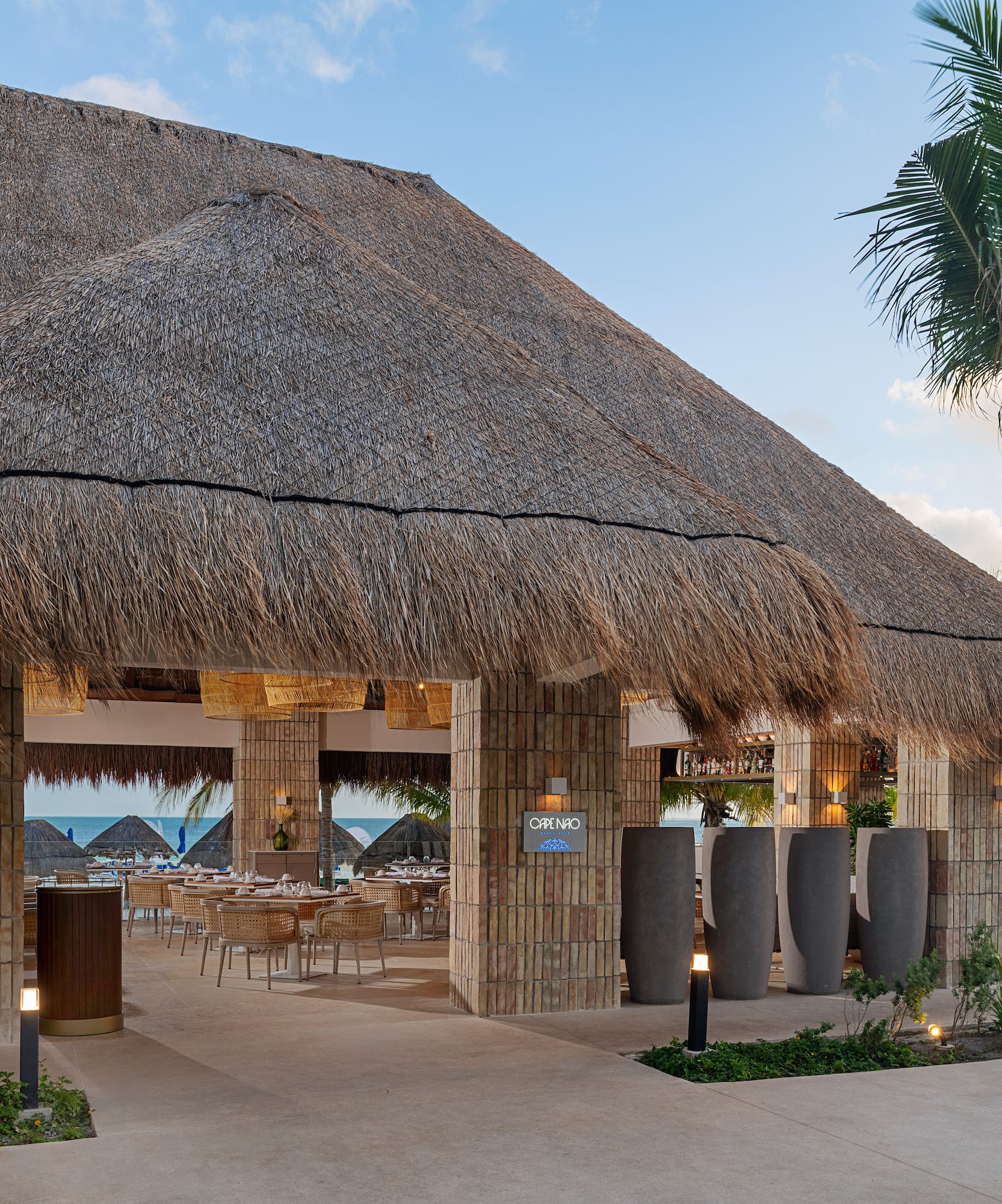 a building with a thatched roof and tables and chairs