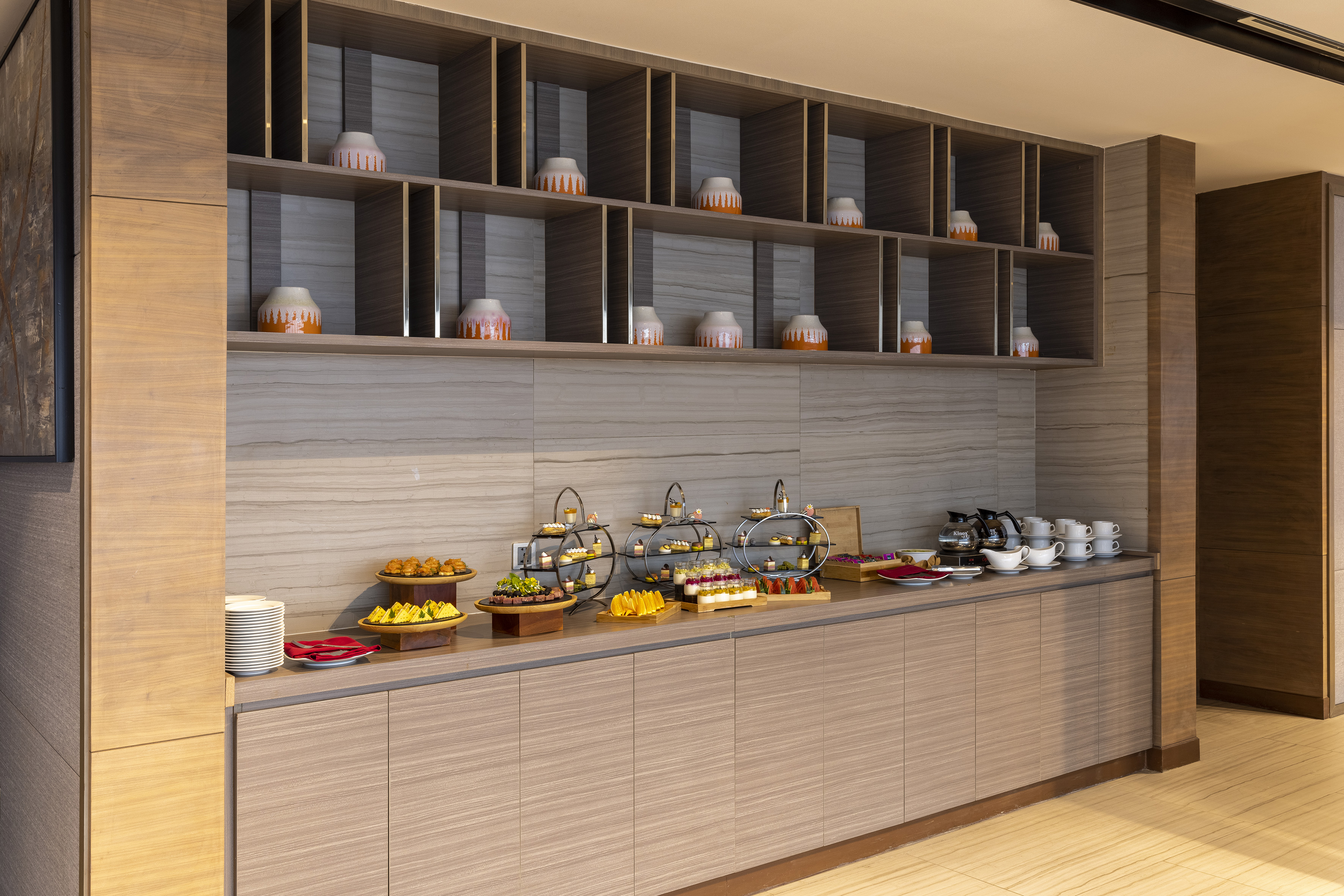 Hotel dessert bar with pastries, fruit, coffee, and tea.