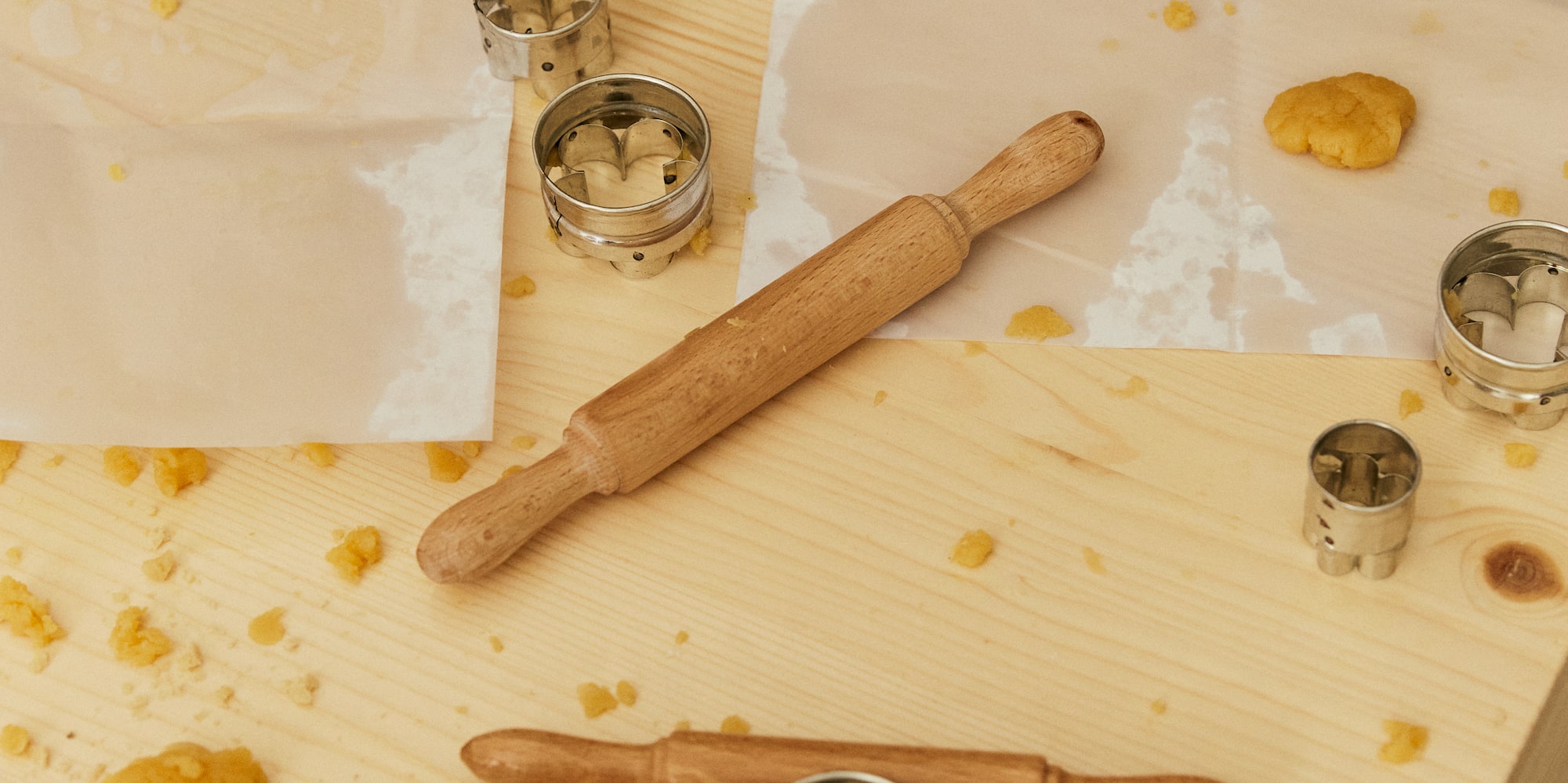 a rolling pin and cookie cutters on a table