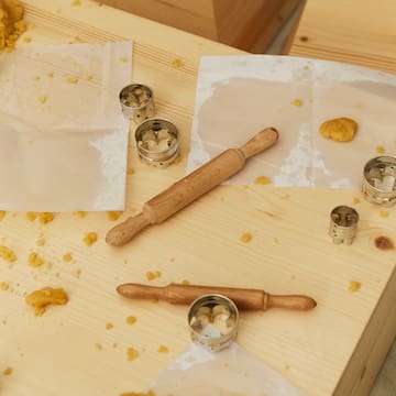 a rolling pin and cookie cutters on a table