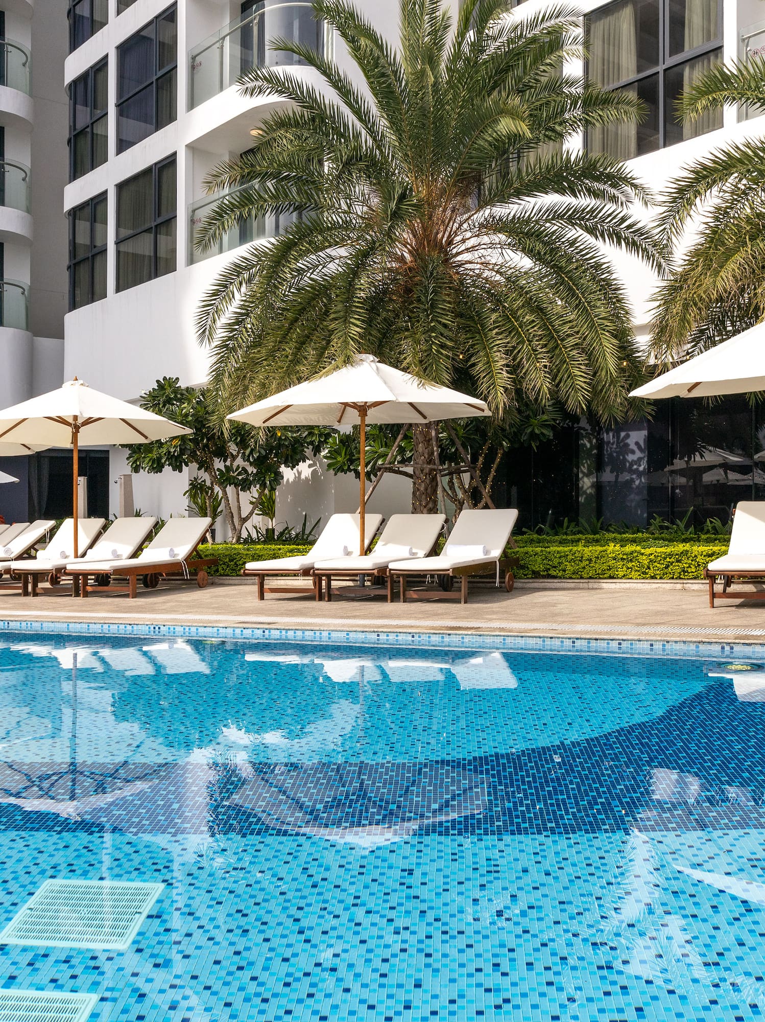 a pool with umbrellas and lounge chairs
