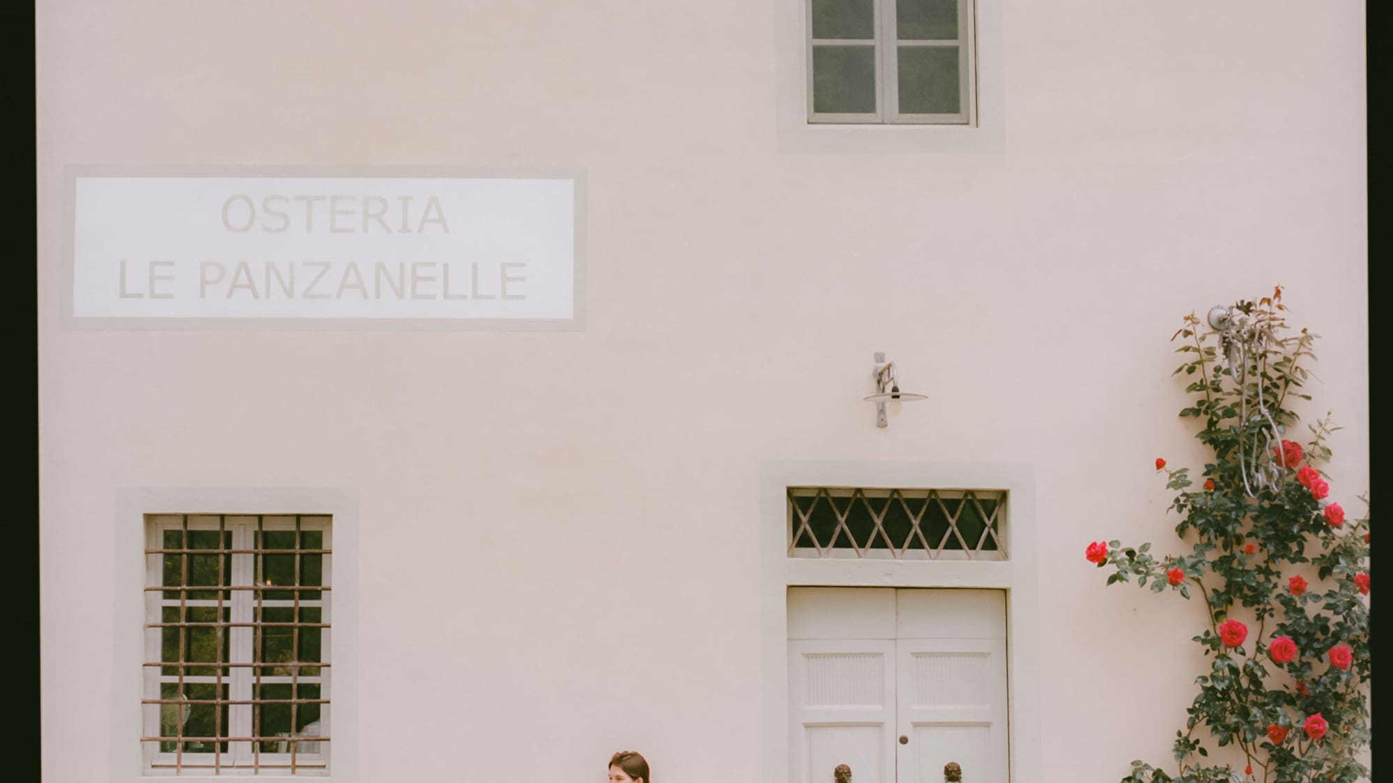 a woman sitting on a bench outside of a building