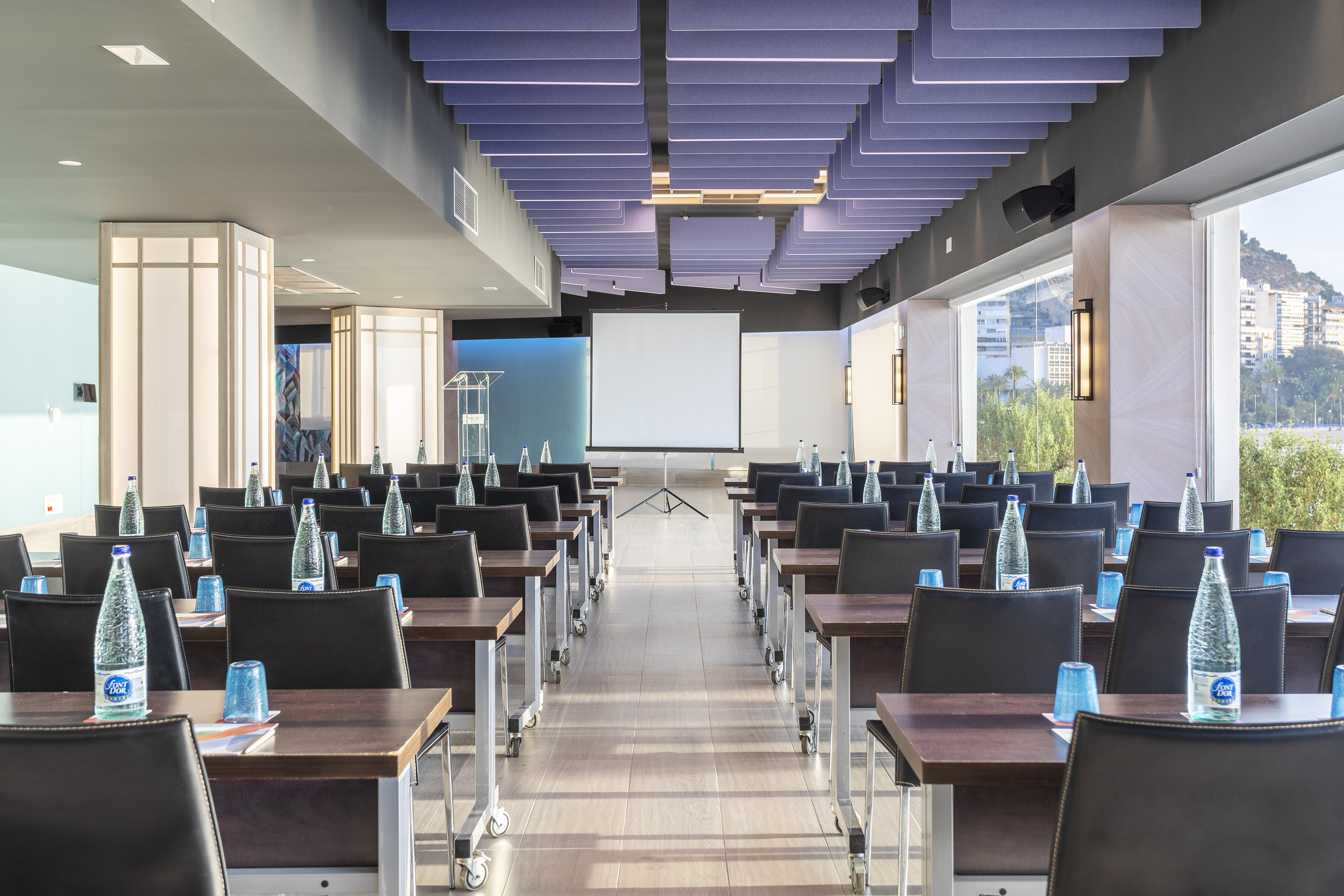 Spacious modern conference room with professional setup and projection screen.