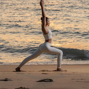 a woman in yoga pose on a beach