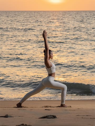 a woman in yoga pose on a beach