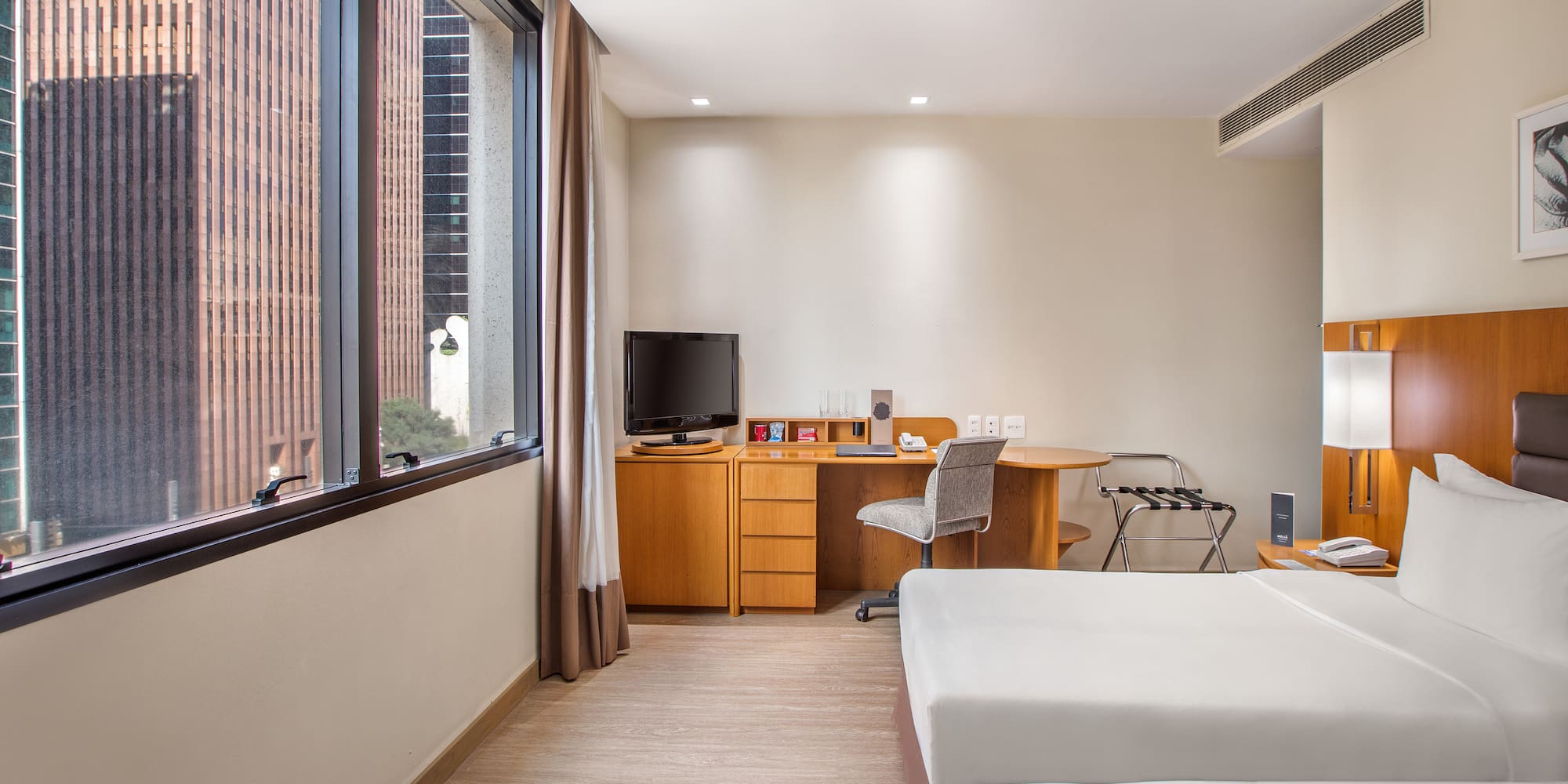 a room with two beds and a desk and a television