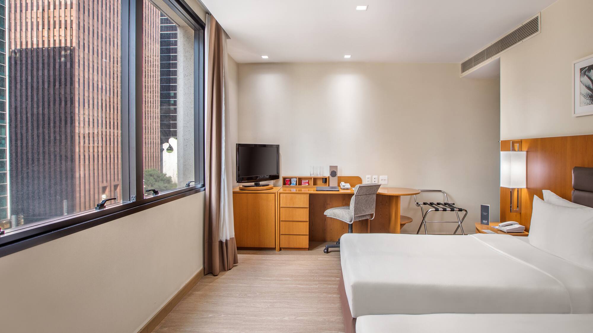 a room with two beds and a desk and a television