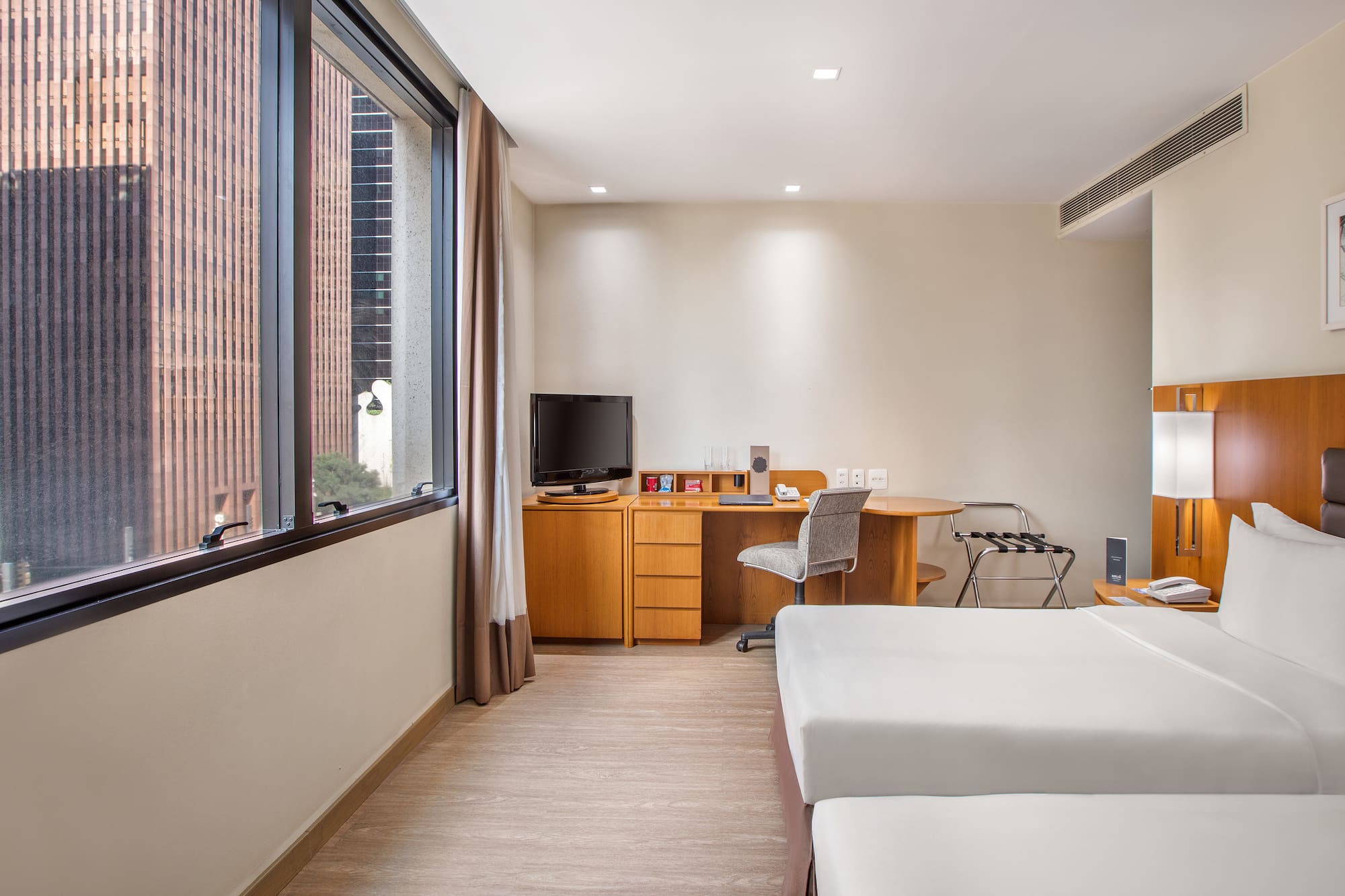 a room with two beds and a desk and a television