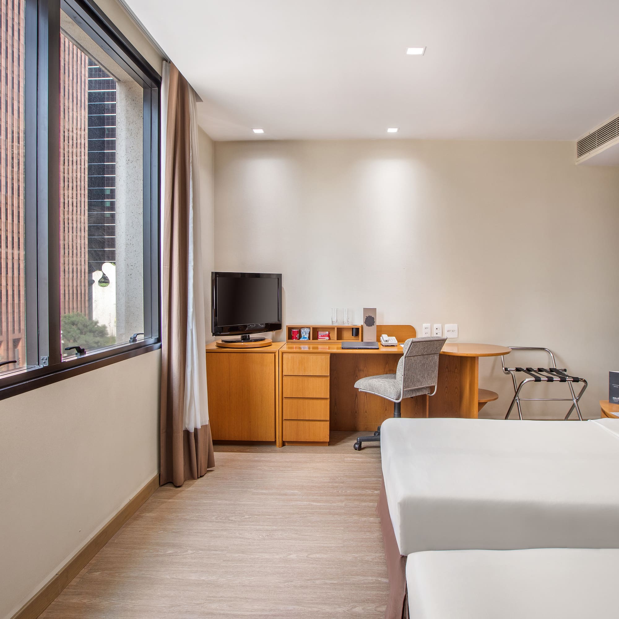 a room with two beds and a desk and a television