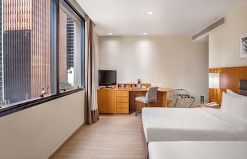 a room with two beds and a desk and a television