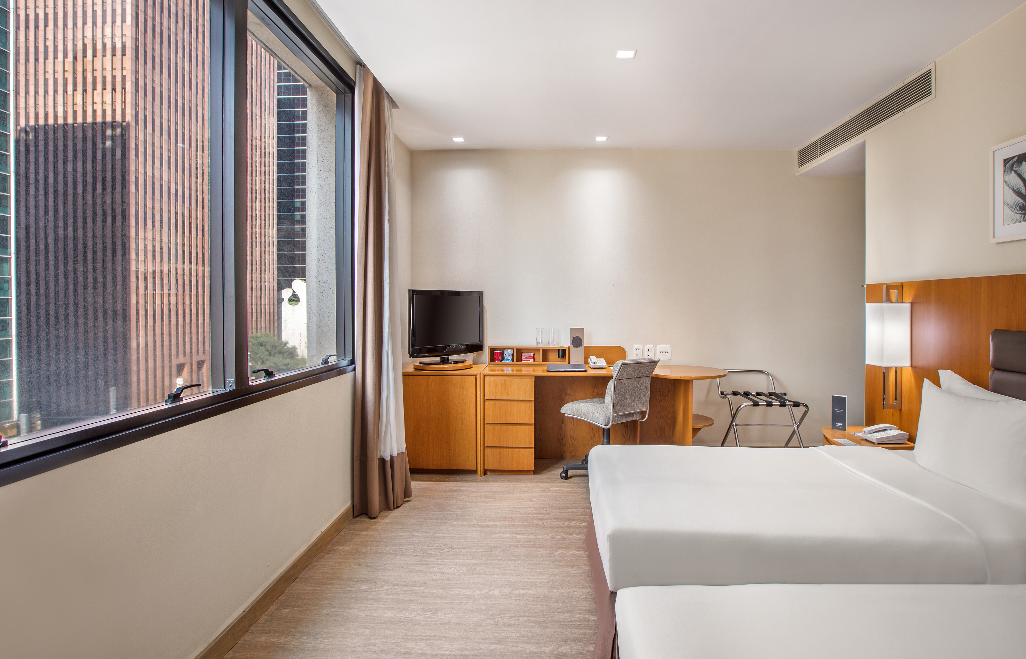 a room with two beds and a desk and a television