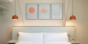 a bed with two lamps above it