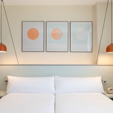 a bed with two lamps above it