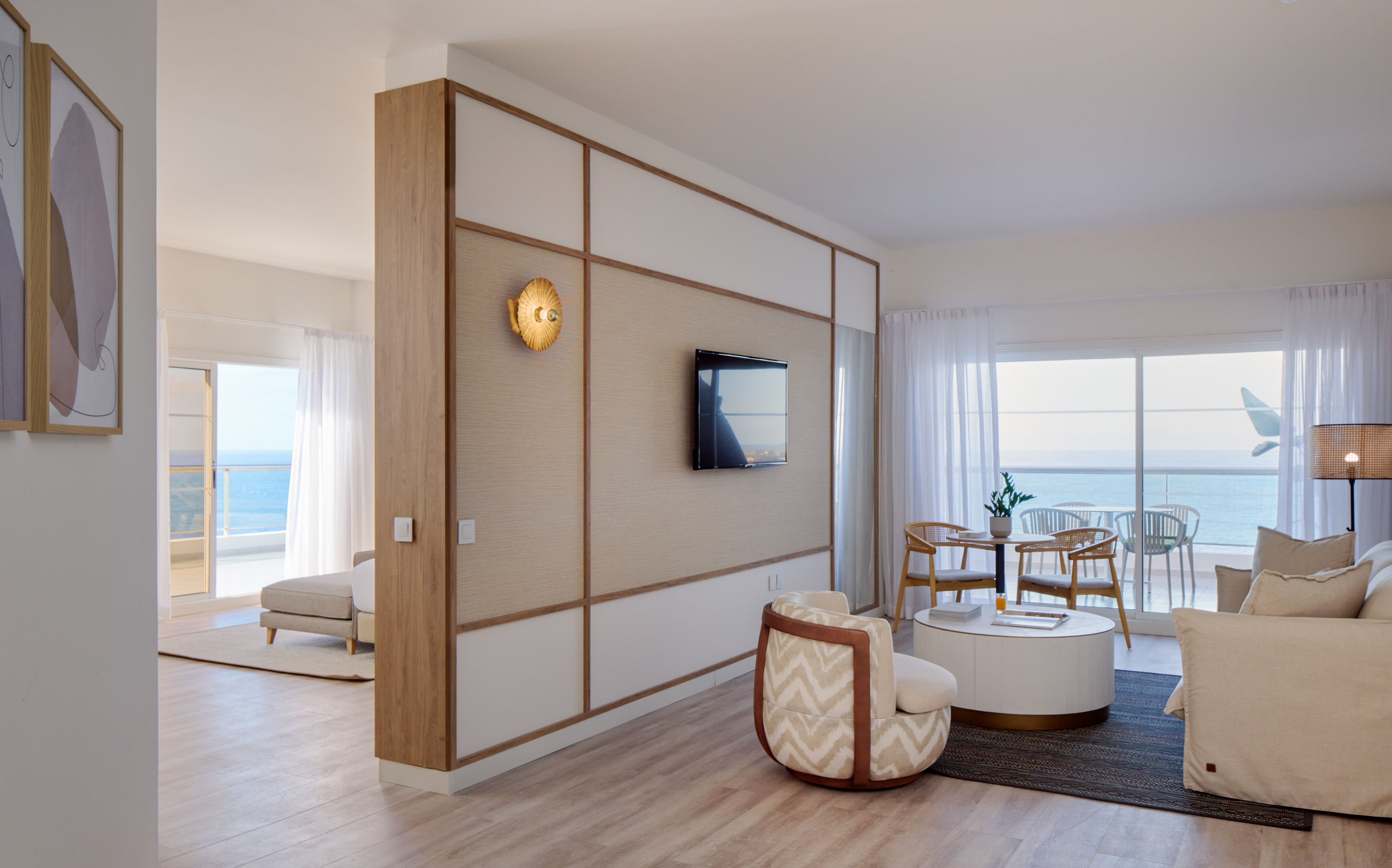 Modern ocean view hotel suite living area with balcony access.