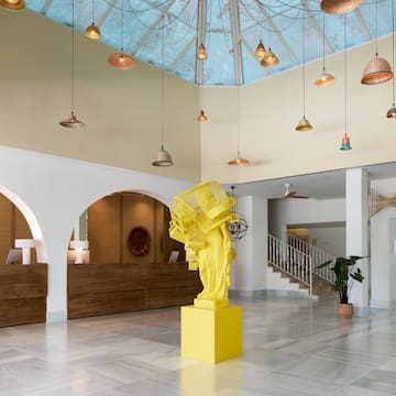 a yellow statue in a room with a blue ceiling and lights