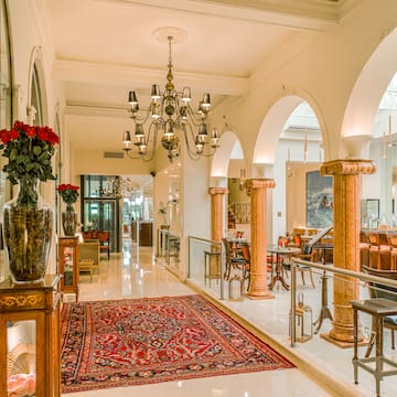 a hallway with a rug and chandelier