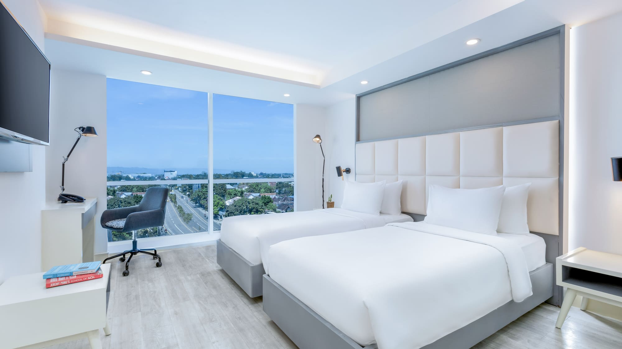 a room with two beds and a desk and a window