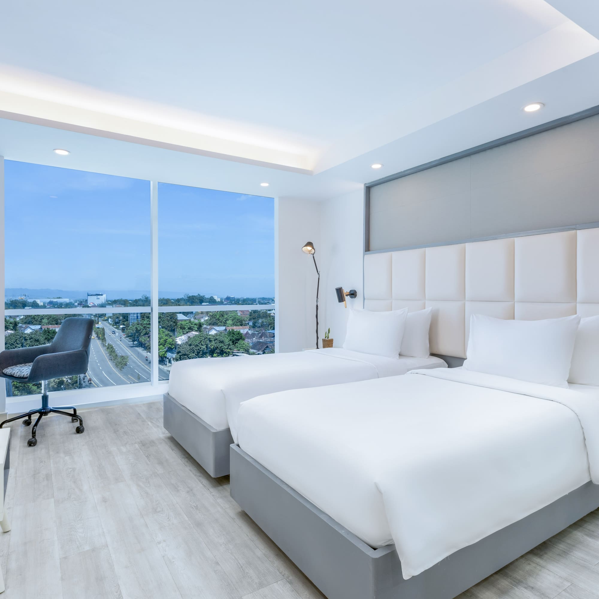 a room with two beds and a desk and a window