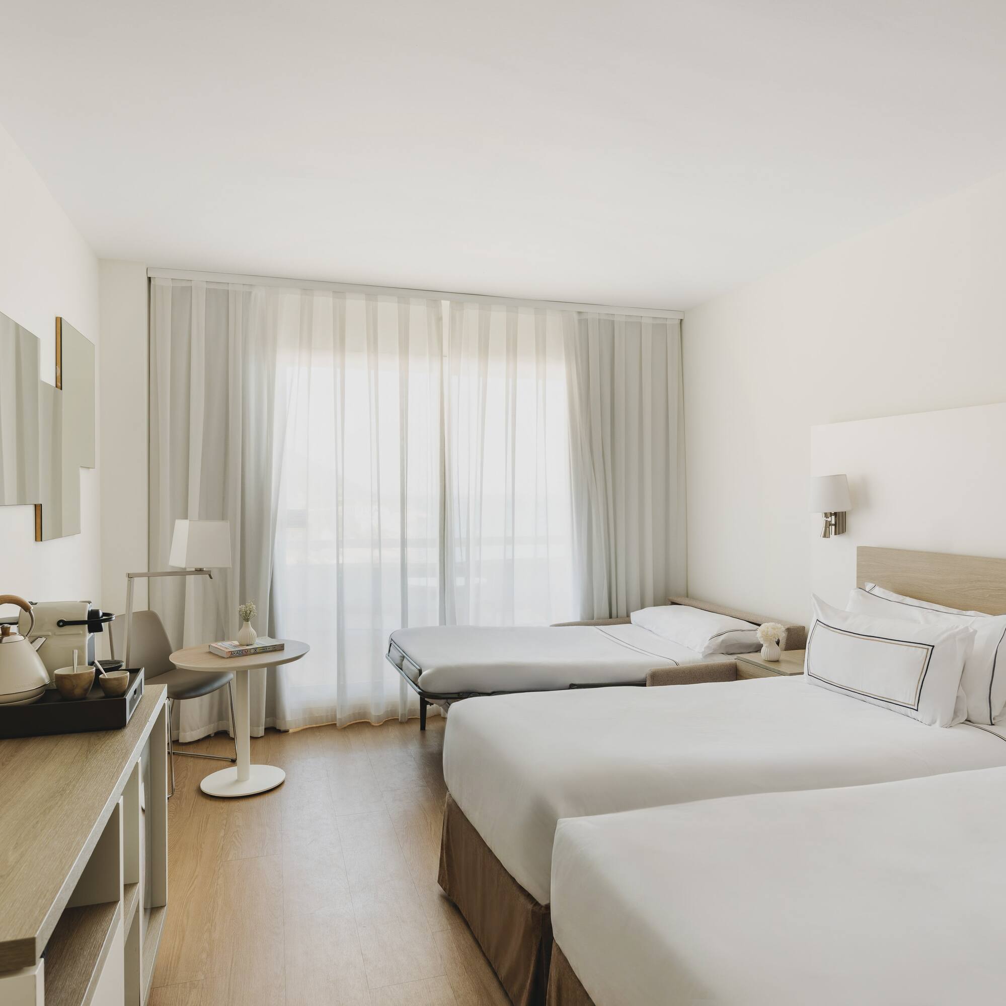 Habitación hotel moderna, dos camas individuales, sofá cama, TV.