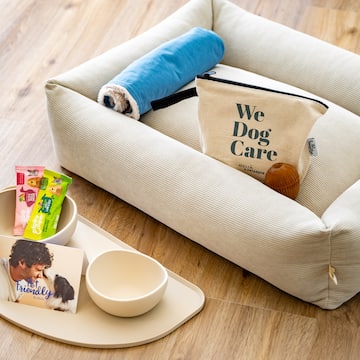 a dog bed with food and a bag on it