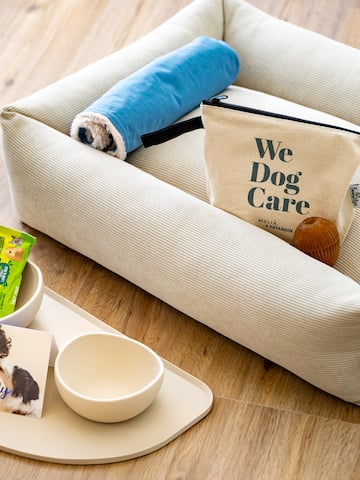 a dog bed with food and a bag on it