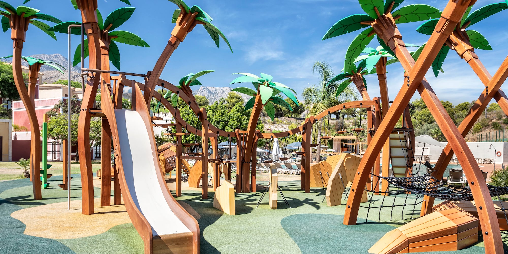 a playground with palm trees and a slide