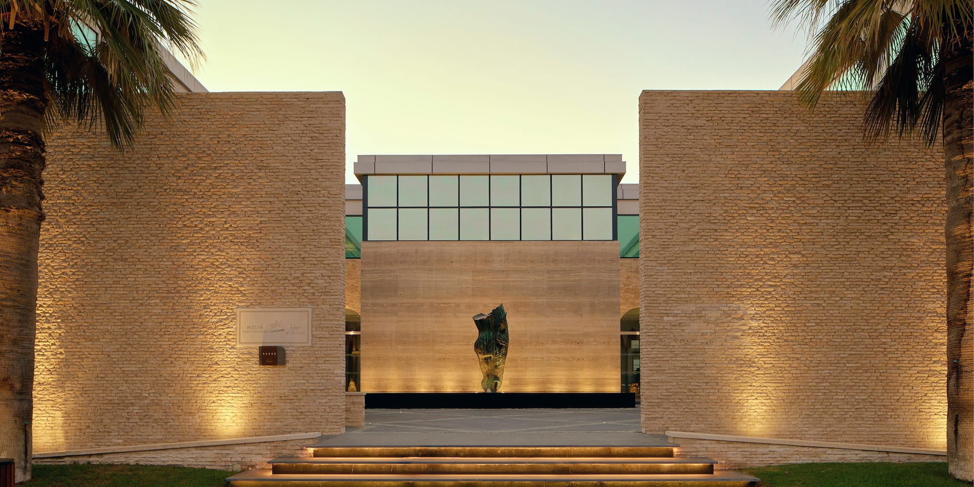 a building with a stone wall and steps leading to a building