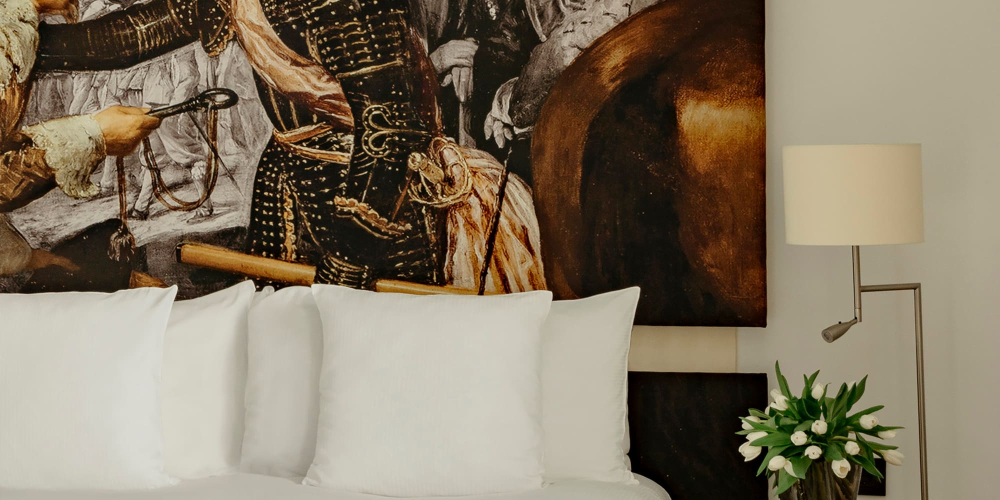 a bed with a painting on the wall