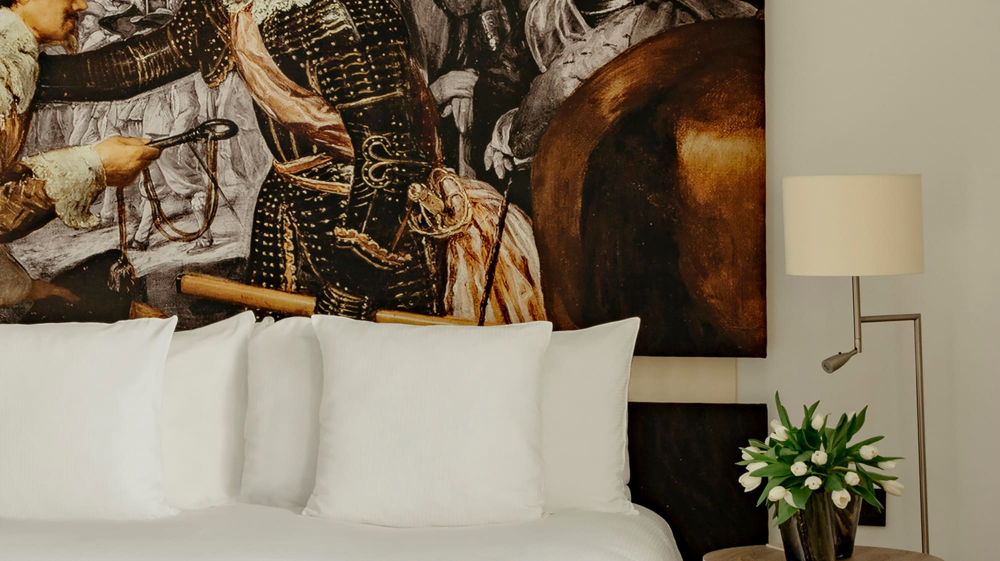 a bed with a painting on the wall